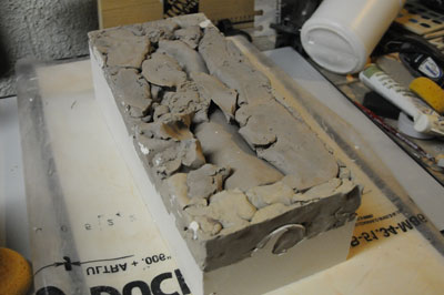 This is the piece after the first part of the mold is done. Carefully take away the scrap clay that you used to block off the other side.