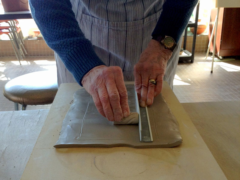Margrit demonstrated how she rolls a straight impression across her slab. The texturized roller is butted against a right-angle piece of trim.