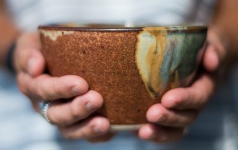 hands holding a small handmade ceramic bowl