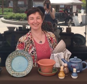 Photo of Karina and some of her pottery
