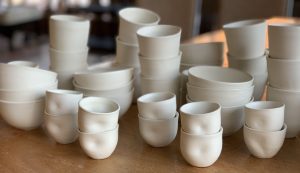 The pure white of bisqued work before glaze, stacked bowls and tumblers - Kelly Zatorski