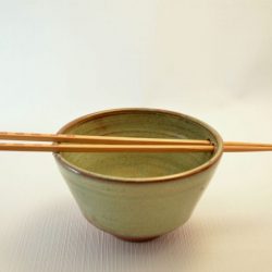 Bowl with holes and rests for chopsticks glazed in sandy yellow over red clay - Karen Hjort-Jensen