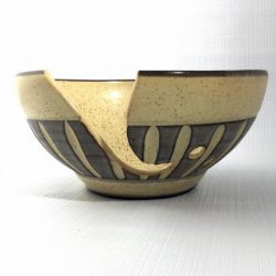 yarn bowl with cutout and holes with black slip carved through and a semi matt clear glaze on speckled clay - Sara Purves