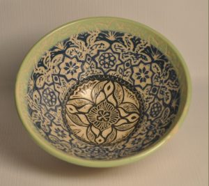 bowl painted with blue, green and black slip and carved through in floral patterns - Karina Bates