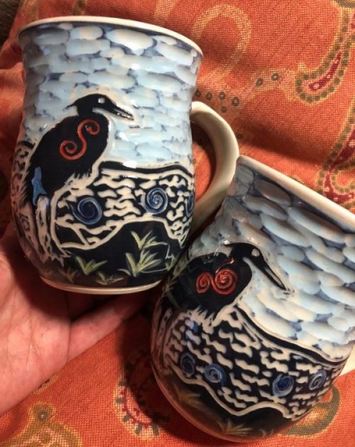 two mugs carved with herons on the shore - Cathy Allen