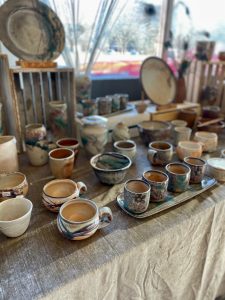 Photo of Ann Randeraad's table of wood fired pottery at KPG's annual Holiday Sale 2021