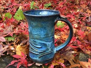 Blue carved mug set in colourful fall leaves - Sara Purves