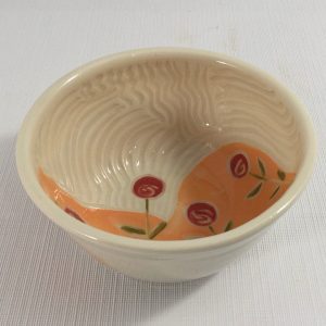 Small bowl with orange background and red flowers carved inside - cathy allen
