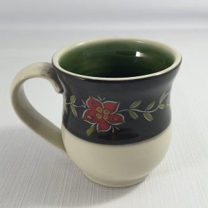mug with green inside and black upper band with carved red flowers and green leaves - cathy allen