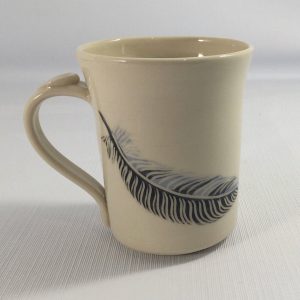 white porcelain mug painted with black and blue feather - Priya Harding