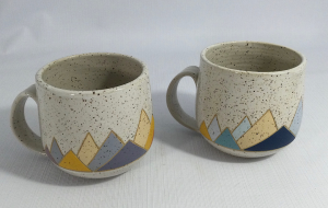 Pair of mugs with carved and painted mountains at base, speckled clay, white glaze - Natalie Miller