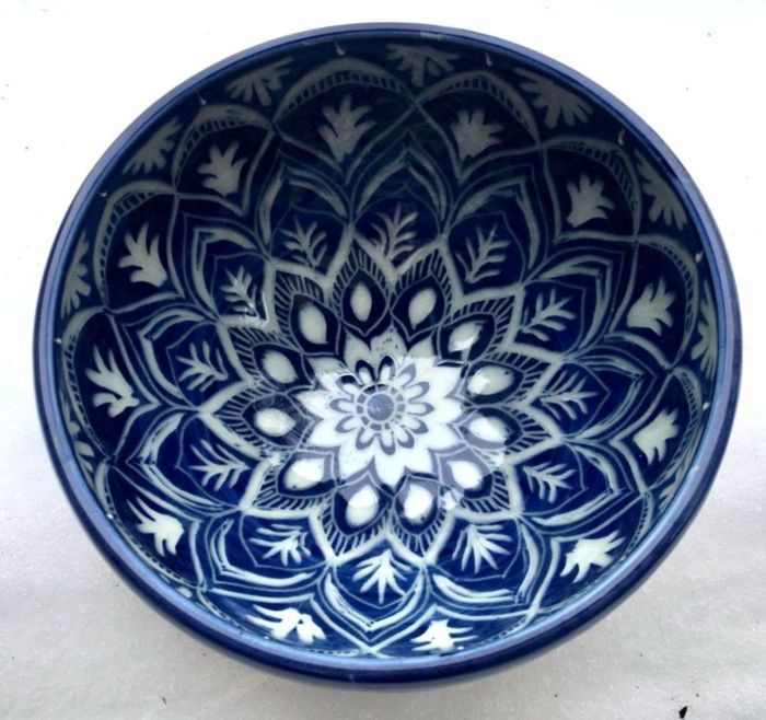 deep bowl in cobalt blue with carving in a mandala pattern through to the white clay below