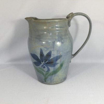 Blue pitcher with single dark blue floral  design  on side of body
