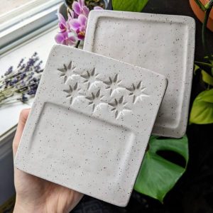 Grey tiles with compass stars impressed into the clay - Holly McGillis