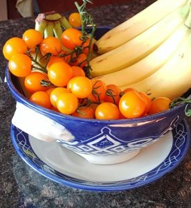 Large berry bowl and plate painted with cobalt blue slip and carved through. Filled with bananas and cherry tomatoes